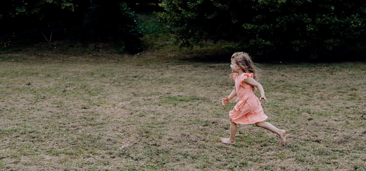Barn springer över gräs